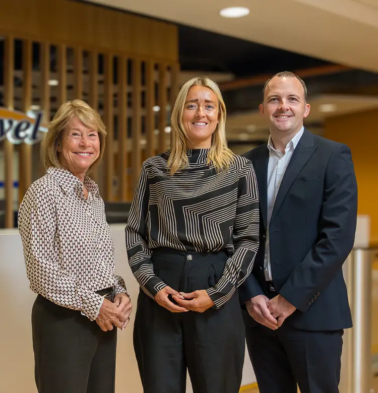 Jonathon, Harriet, and Irene standing outside of the Hays Travel head office